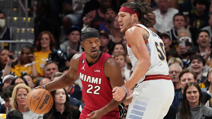 Miami Heat forward Jimmy Butler dribbles the ball against Denver Nuggets forward Aaron Gordon during the first quarter in game five of the 2023 NBA Finals at Ball Arena. 