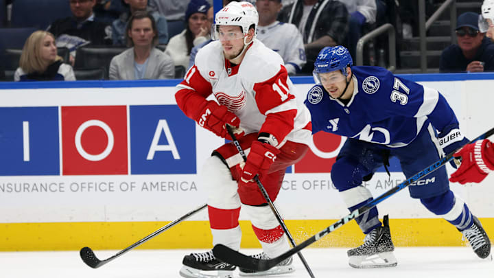 Apr 11, 2025; Tampa, Florida, USA; Detroit Red Wings right wing Vladimir Tarasenko (11) skates with the puck as Tampa Bay Lightning center Yanni Gourde (37) defends during the third period at Amalie Arena. Mandatory Credit: Kim Klement Neitzel-Imagn Images
