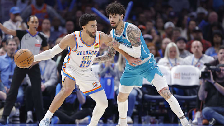 Jan 5, 2026; Oklahoma City, Oklahoma, USA; Oklahoma City Thunder guard Ajay Mitchell (25) drives against Charlotte Hornets guard Lamelo Ball (1) during the second half at Paycom Center. Mandatory Credit: Alonzo Adams-Imagn Images