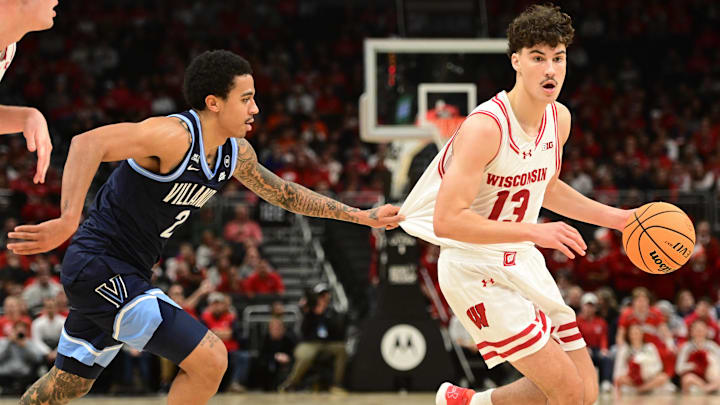 Dec 19, 2025; Milwaukee, Wisconsin, USA; Wisconsin Badgers guard Hayden Jones (13) drives for the basket against Villanova Wildcats guard Bryce Lindsay (2) first half at the Fiserv Forum. Mandatory Credit: Benny Sieu-Imagn Images