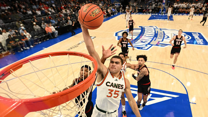 Mar 12, 2026; Charlotte, NC, USA; Miami (FL) Hurricanes guard Dante Allen (35) scores as Louisville Cardinals guard Ryan Conwell (3) defends in the second half at Spectrum Center. Mandatory Credit: Bob Donnan-Imagn Images