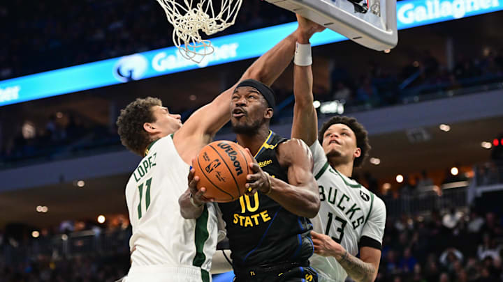 Feb 10, 2025; Milwaukee, Wisconsin, USA;  Golden State Warriors guard Stephen Curry (30) looks for a shot between Milwaukee Bucks center Brook Lopez (11) and guard Ryan Rollins (13) in the second quarter at Fiserv Forum. Mandatory Credit: Benny Sieu-Imagn Images