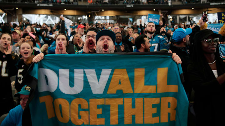 Season ticket holder of 25 years, John Jackett (cq), holds up a Jacksonville Jaguars banner as he Season ticket holder of 25 years, John Jackett (cq), holds up a Jacksonville Jaguars banner as he