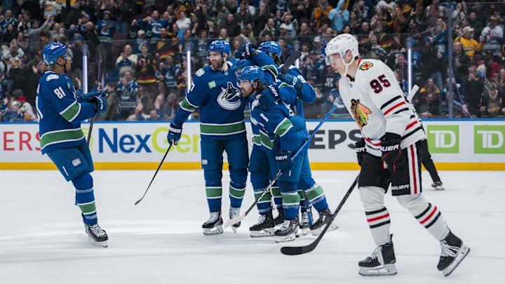 Mar 15, 2025; Vancouver, British Columbia, CAN; Chicago Blackhawks forward Ilya Mikheyev (95) reacts as Vancouver Canucks forward Dakota Joshua (81) and forward Conor Garland (8) and defenseman Derek Forbort (27) and defenseman Vittorio Mancini (90) and forward Pius Suter (24) celebrate Suter’s goal against the Chicago Blackhawks in the third period at Rogers Arena. Mandatory Credit: Bob Frid-Imagn Images