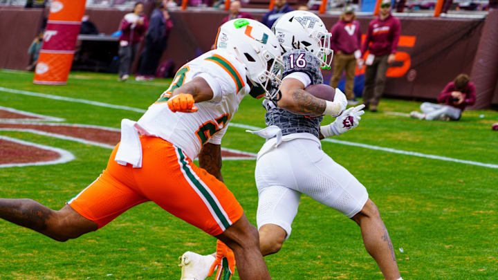 Nov 22, 2025; Blacksburg, Virginia, USA; Virginia Tech Hokies running back Jeffrey Overton (16) runs in for the touchdown against Miami (FL) Hurricanes defensive back Dylan Day (23) during the third quarter at Lane Stadium. Mandatory Credit: Neville E. Guard-Imagn Images