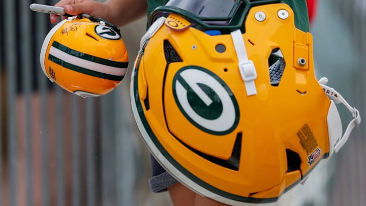 A young fan carries an autographed mini helmet in one hand and Green Bay Packers offensive tackle Zach Tom’s helmet in the other as Tom rides a bicycle to practice during the first day of training camp on Wednesday, July 23, 2025, at Ray Nitschke Field in Ashwaubenon, Wis. 
Tork Mason/USA TODAY NETWORK-Wisconsin