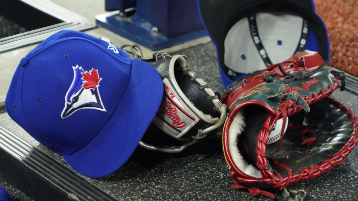 Apr 27, 2024; Toronto, Ontario, CAN; A pair of Toronto Blue Jays hats and gloves in the dugout during the first inning against the Los Angeles Dodgers at Rogers Centre.