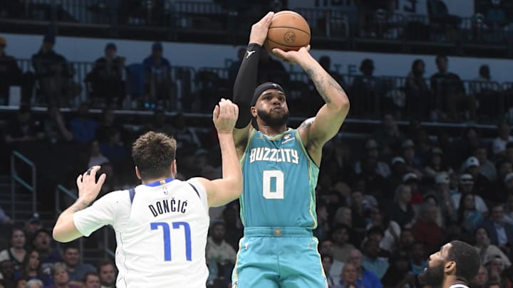 Apr 9, 2024; Charlotte, North Carolina, USA; Charlotte Hornets forward Miles Bridges (0) shoots as he is defended by Dallas Mavericks guard Luka Doncic (77) during the second half at the Spectrum Center. Mandatory Credit: Sam Sharpe-USA TODAY Sports Apr 9, 2024; Charlotte, North Carolina, USA; Charlotte Hornets forward Miles Bridges (0) shoots as he is defended by Dallas Mavericks guard Luka Doncic (77) during the second half at the Spectrum Center. Mandatory Credit: Sam Sharpe-USA TODAY Sports