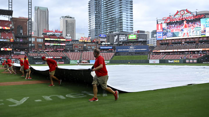 Jul 13, 2025; St. Louis, Missouri, USA;  St. Louis Cardinals grounds crew pulls the tarp on the field during a rain delay in the third inning of a game between the St. Louis Cardinals and the Atlanta Braves at Busch Stadium. Mandatory Credit: Jeff Curry-Imagn Images