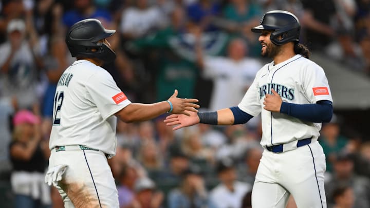 Aug 5, 2025; Seattle, Washington, USA; Seattle Mariners first baseman Josh Naylor (12) and third baseman Eugenio Suarez (28) celebrate after both scored a run against the Chicago White Sox during the sixth inning at T-Mobile Park. Mandatory Credit: Steven Bisig-Imagn Images