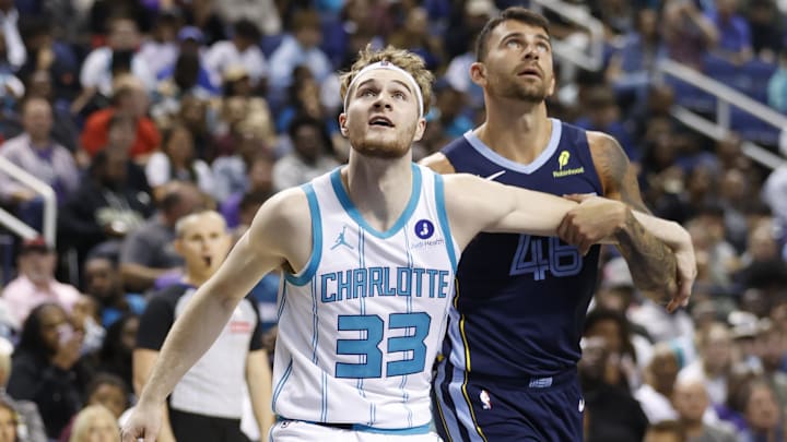 Oct 15, 2025; Greensboro, North Carolina, USA; Charlotte Hornets forward Liam McNeeley (33) boxes out Memphis Grizzlies guard John Konchar (46) during the second half at First Horizon Coliseum. Mandatory Credit: Brian Westerholt-Imagn Images