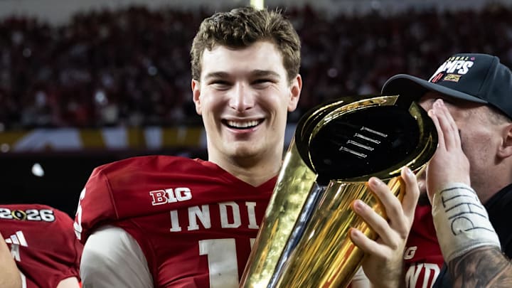 Jan 19, 2026; Miami Gardens, FL, USA; Indiana Hoosiers quarterback Fernando Mendoza (16) celebrates with the trophy after defeating the Miami Hurricanes in the College Football Playoff National Championship game at Hard Rock Stadium. Mandatory Credit: Mark J. Rebilas-Imagn Images