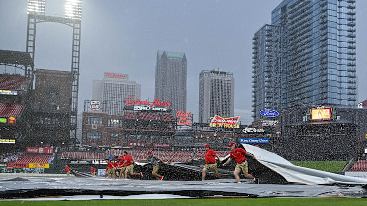 May 4, 2024; St. Louis, Missouri, USA;  St. Louis Cardinals grounds crew pulls the tarp on the field as heavy rain falls during the tenth inning of a game against the Chicago White Sox at Busch Stadium. Mandatory Credit: Jeff Curry-USA TODAY Sports