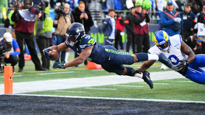 Jan 25, 2026; Seattle, WA, USA; Seattle Seahawks running back Kenneth Walker III (9) reaches for a touchdown against Los Angeles Rams linebacker Byron Young (0) in the first half in the 2026 NFC Championship Game at Lumen Field. Mandatory Credit: Steven Bisig-Imagn Images