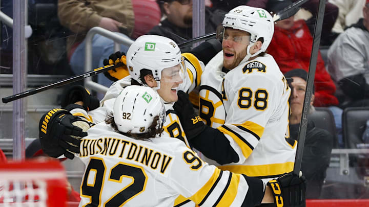 Mar 21, 2026; Detroit, Michigan, USA; Boston Bruins defenseman Nikita Zadorov (91) celebrates with right wing David Pastrnak (88) and center Marat Khusnutdinov (92) after scoring a goal in the third period against the Detroit Red Wings at Little Caesars Arena. Mandatory Credit: Brian Bradshaw Sevald-Imagn Images