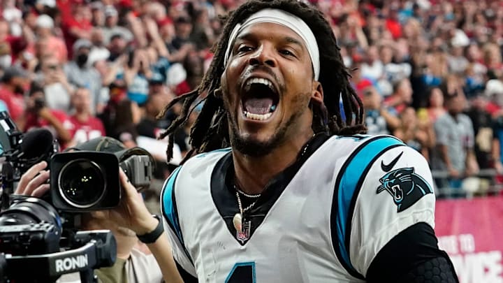 Carolina Panthers quarterback Cam Newton yells \"I'm back!\" after scoring a rushing touchdown against the Arizona Cardinals in a game in 2021.