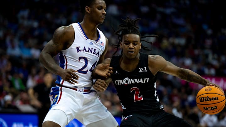 Cincinnati Bearcats guard Jizzle James (2) drives on Kansas Jayhawks forward K.J. Adams Jr. (24) in the first half of the Big 12 Conference tournament game between Cincinnati Bearcats and Kansas Jayhawks at T-Mobile Center in Kansas City, Mo., on Wednesday, March 13, 2024.