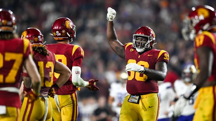 Nov 4, 2023; Los Angeles, California, USA; USC Trojans defensive lineman Bear Alexander (90) celebrates with linebacker Eric Gentry (18) and other teammates against the Washington Huskies during the fourth quarter at United Airlines Field at Los Angeles Memorial Coliseum. Mandatory Credit: Jonathan Hui-USA TODAY Sports