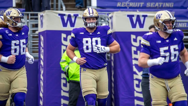 Zach Henning, wearing a tight-end jersey, is flanked by Hatchetts. 