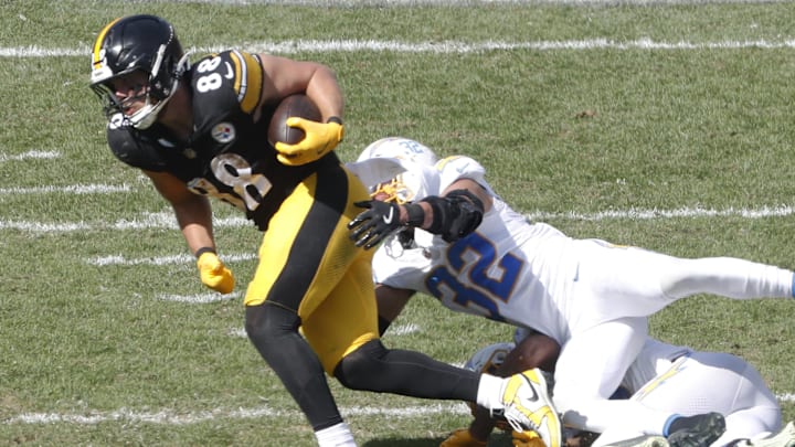 Sep 22, 2024; Pittsburgh, Pennsylvania, USA;  Pittsburgh Steelers tight end Pat Freiermuth (88) runs after a catch as Los Angeles Chargers safety Derwin James Jr. (bottom) and safety Alohi Gilman (32) tackle during the third quarter at Acrisure Stadium. Pittsburgh won 20-10. Mandatory Credit: Charles LeClaire-Imagn Images