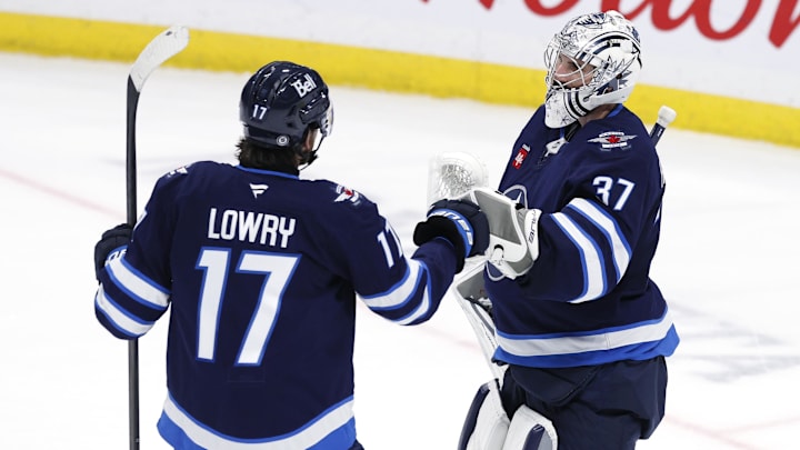 Nov 3, 2024; Winnipeg, Manitoba, CAN; Winnipeg Jets center Adam Lowry (17) and Winnipeg Jets goaltender Connor Hellebuyck (37) celebrate their victory over the Tampa Bay Lightning at Canada Life Centre. Mandatory Credit: James Carey Lauder-Imagn Images