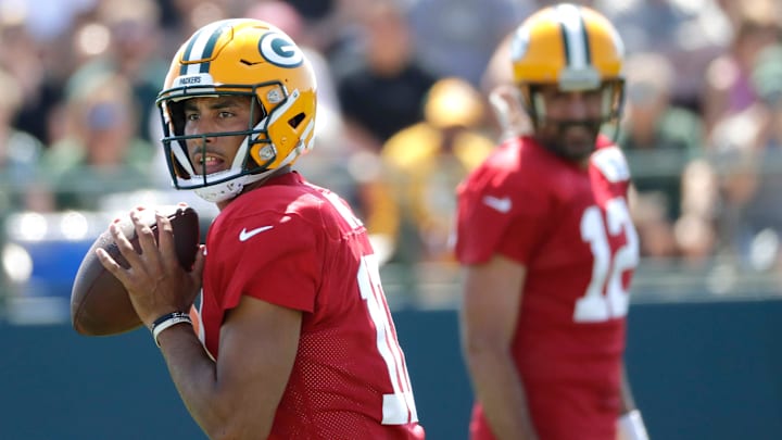 Green Bay Packers quarterback Jordan Love (10) passes as Aaron Rodgers looks on during training camp in 2022.