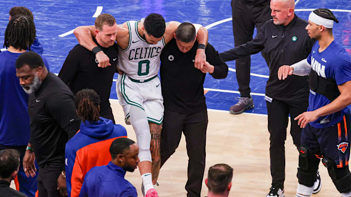 May 12, 2025; New York, New York, USA; Boston Celtics forward Jayson Tatum (0) is helped off the court by after an injury in the second half during game four of the second round for the 2025 NBA Playoffs against the New York Knicks at Madison Square Garden. Tatum would leave the game with an injury after this play. Mandatory Credit: Vincent Carchietta-Imagn Images