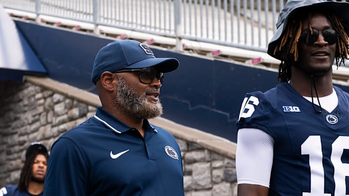 Penn State associate head coach Terry Smith talks with cornerback Elliot Washington II at Beaver Stadium.
