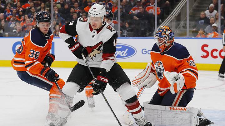 Nov 4, 2019; Edmonton, Alberta, CAN; Arizona Coyotes forward Christian Dvorak (18) battles for a loose puck with Edmonton Oilers defensemen Joel Persson (36) in front of goaltender Mikko Koskinen (19) during the second period at Rogers Place. Mandatory Credit: Perry Nelson-Imagn Images Nov 4, 2019; Edmonton, Alberta, CAN; Arizona Coyotes forward Christian Dvorak (18) battles for a loose puck with Edmonton Oilers defensemen Joel Persson (36) in front of goaltender Mikko Koskinen (19) during the second period at Rogers Place. Mandatory Credit: Perry Nelson-Imagn Images