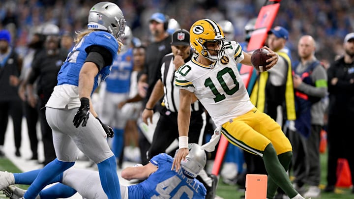 Green Bay Packers quarterback Jordan Love (10) gets forced out of bounds by Detroit Lions linebackers Jack Campbell (46) and Alex Anzalone.