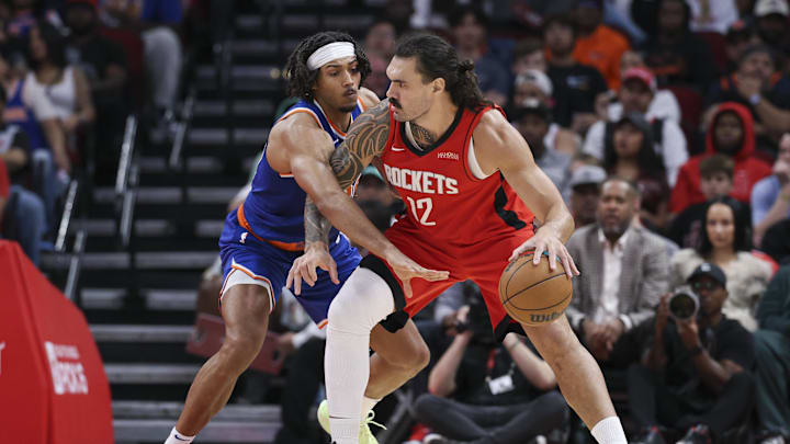 Nov 4, 2024; Houston, Texas, USA; Houston Rockets center Steven Adams (12) controls the ball as New York Knicks center Jericho Sims (20) defends during the second half at Toyota Center. Mandatory Credit: Troy Taormina-Imagn Images