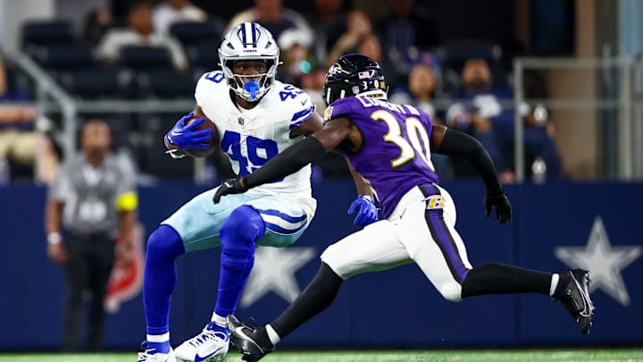 Dallas Cowboys tight end John Stephens Jr. runs with the ball as Baltimore Ravens cornerback Reuben Lowery defends 