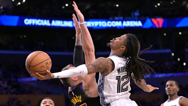 Jan 2, 2026; Los Angeles, California, USA; Los Angeles Lakers guard Luka Doncic (77) defends a shot by Memphis Grizzlies guard Ja Morant (12) in the first half at Crypto.com Arena. Mandatory Credit: Jayne Kamin-Oncea-Imagn Images
