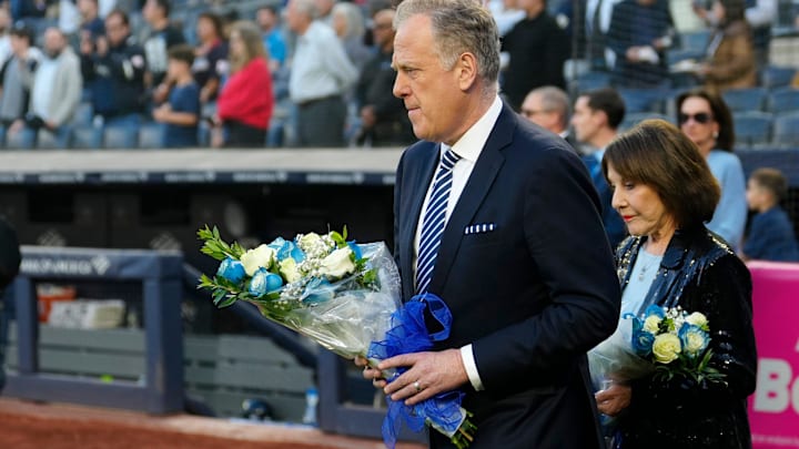 Michael Kay and Suzyn Waldman are shown just before laying flowers at home plate in memory of John Sterling, Monday, May 4, 2026, at Yankee Stadium.