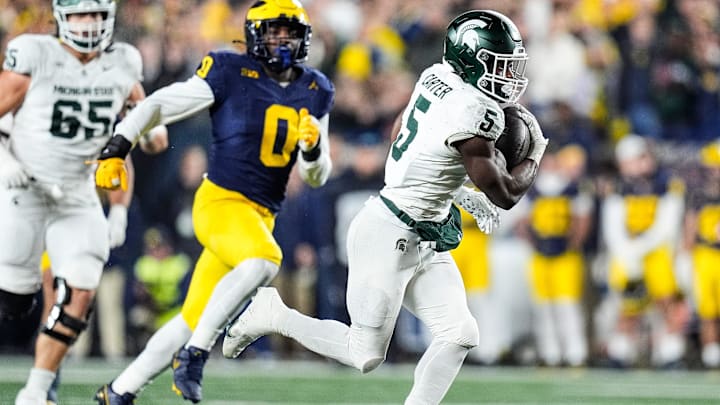 Michigan State running back Nate Carter (5) runs against Michigan defensive end Josaiah Stewart (0) during the first half at Michigan Stadium in Ann Arbor on Saturday, Oct. 26, 2024.