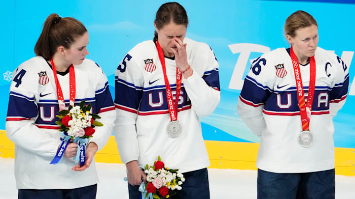 Team United States forward Dani Cameranesi (24), Team United States forward Alex Carpenter (25), and Team United States forward Kendall Coyne Schofield (26) stand on the ice during the medals ceremony during the Beijing 2022 Olympic Winter Games at Wukesong Sports Centre.