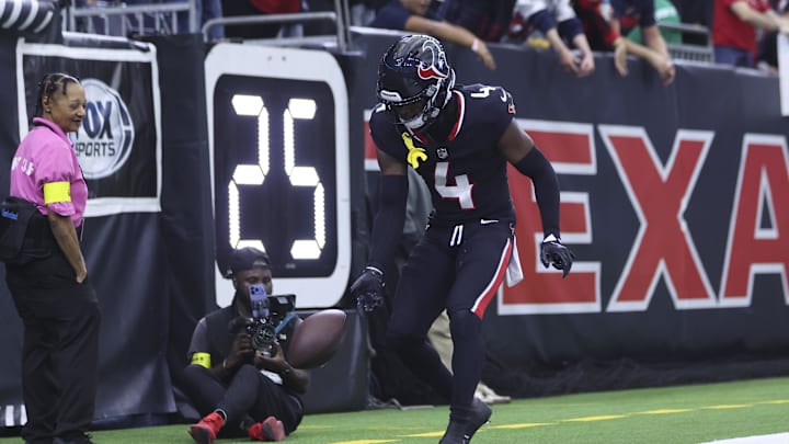 Dec 14, 2025; Houston, Texas, USA; Houston Texans cornerback Kamari Lassiter (4) spins the ball after making an interception during the game against the Arizona Cardinals at NRG Stadium. Mandatory Credit: Troy Taormina-Imagn Images