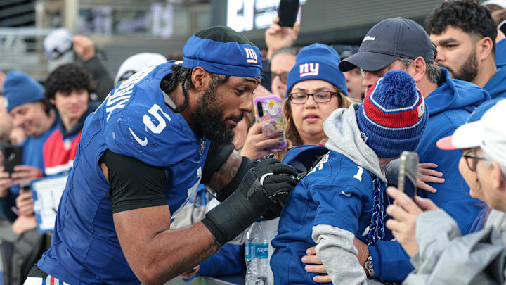 Dec 29, 2024; East Rutherford, New Jersey, USA; New York Giants linebacker Kayvon Thibodeaux (5) signs an autograph after the game against the Indianapolis Colts at MetLife Stadium.  