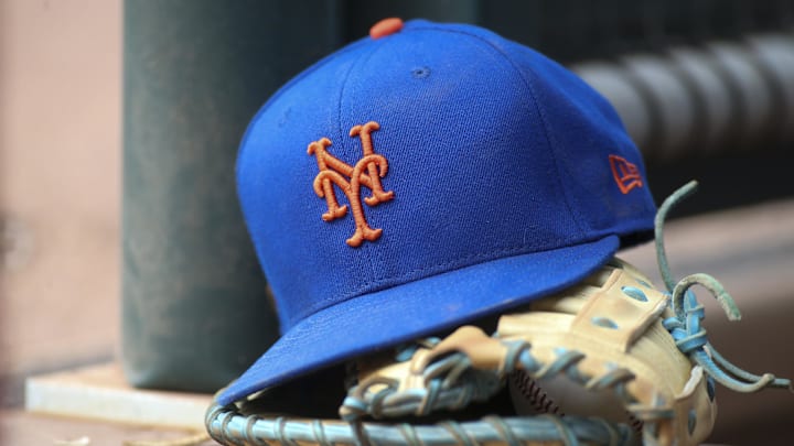 Jul 13, 2022; Atlanta, Georgia, USA; A detailed view of a New York Mets hat and glove in the dugout against the Atlanta Braves in the eighth inning at Truist Park. 