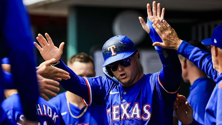 Apr 2, 2025; Cincinnati, Ohio, USA; Texas Rangers designated hitter Joc Pederson (4) high fives teammates after scoring on a RBI double hit by shortstop Josh Smith (not pictured) in the fourth inning against the Cincinnati Reds at Great American Ball Park.