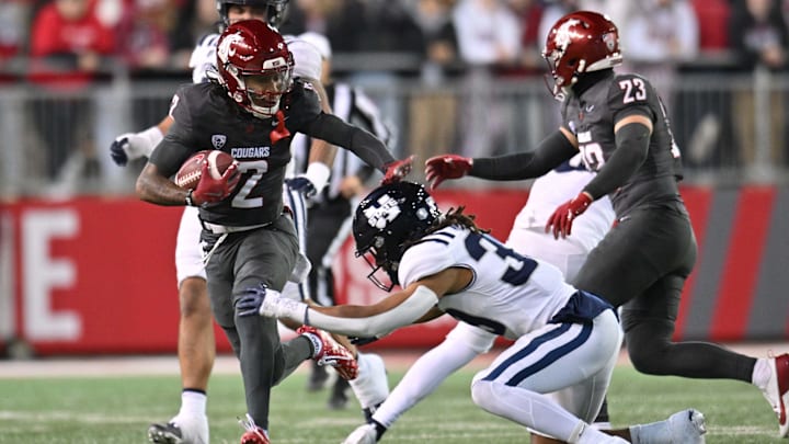 Nov 9, 2024; Pullman, Washington, USA; Washington State Cougars wide receiver Kyle Williams (2) is tackled by Utah State Aggies linebacker Jadon Pearson (39) in the first half at Gesa Field at Martin Stadium. Mandatory Credit: James Snook-Imagn Images