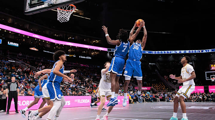 Mar 11, 2026; Kansas City, MO, USA; BYU Cougars forward Khadim Mboup (7) and BYU Cougars forward Kennard Davis Jr. (30) rebound during the first half at T-Mobile Center. Mandatory Credit: William Purnell-Imagn Images
