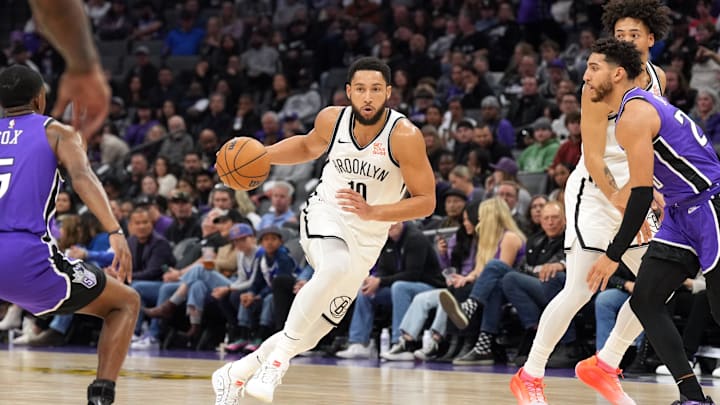 Nov 24, 2024; Sacramento, California, USA; Brooklyn Nets guard Ben Simmons (10) dribbles against Sacramento Kings guards De'Aaron Fox (left) and Colby Jones (right) during the second quarter at Golden 1 Center. Mandatory Credit: Darren Yamashita-Imagn Images