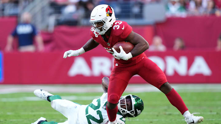 Nov 10, 2024; Glendale, Arizona, USA; Arizona Cardinals running back Trey Benson (33) runs by New York Jets safety Tony Adams (22) during the first half at State Farm Stadium. Mandatory Credit: Joe Camporeale-Imagn Images