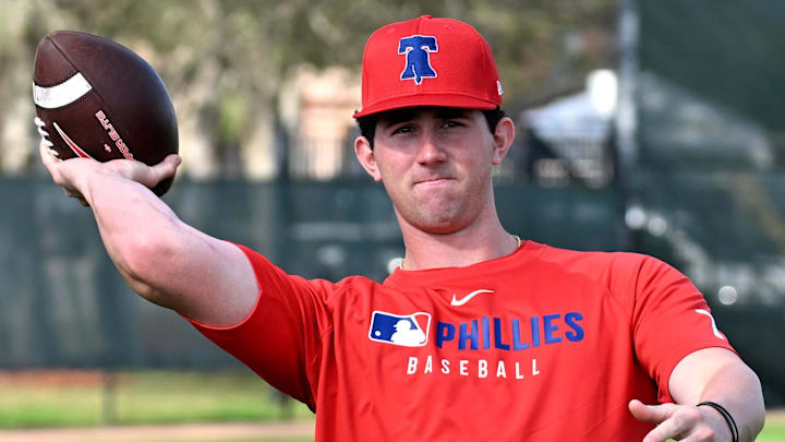 Feb 12, 2025; Clearwater, FL, USA; Philadelphia Phillies pitcher Andrew Painter (76) throws a football during a spring training workout at Carpenter Complex. Feb 12, 2025; Clearwater, FL, USA; Philadelphia Phillies pitcher Andrew Painter (76) throws a football during a spring training workout at Carpenter Complex.