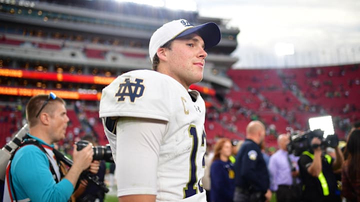 Nov 30, 2024; Los Angeles, California, USA; Notre Dame Fighting Irish quarterback Riley Leonard (13) reacts following the victory against the Southern California Trojans during the second half at the Los Angeles Memorial Coliseum. Mandatory Credit: Gary A. Vasquez-Imagn Images