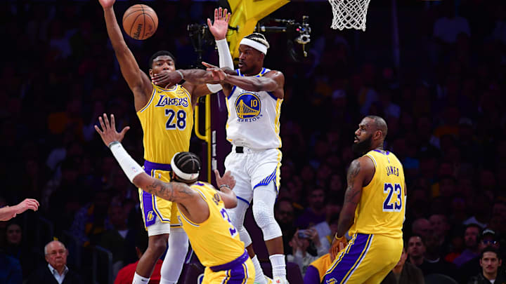 Apr 3, 2025; Los Angeles, California, USA; Golden State Warriors forward Jimmy Butler III (10) passes the ball against Los Angeles Lakers forward Rui Hachimura (28) guard Jordan Goodwin (30) and forward LeBron James (23) during the first half at Crypto.com Arena.