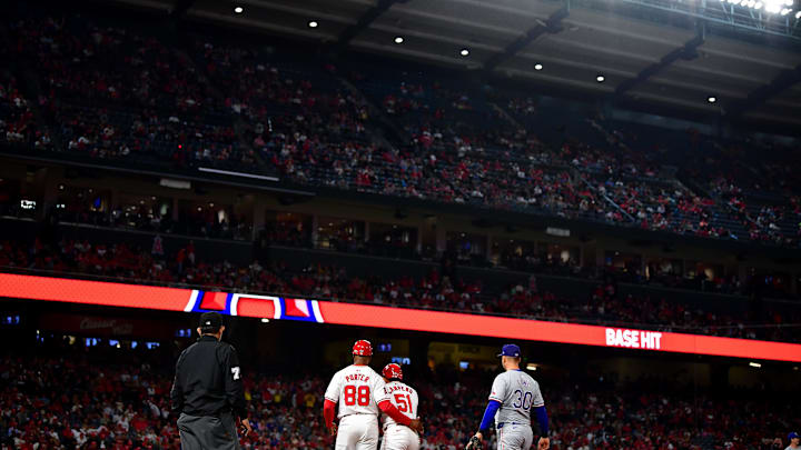 Angels right fielder Gustavo Campero (51) is greeted by first base coach Bo Porter (88) after reaching first on a single against the Texas Rangers during the fifth inning at Angel Stadium on Sept. 27, 2024.