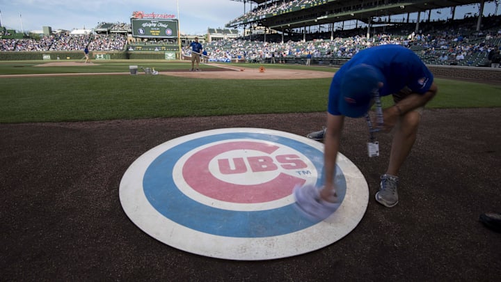 Jun 19, 2017; Chicago, IL, USA; A member of the grounds crew wipes off the Chicago Cubs' on deck logo prior to a game against the San Diego Padres at Wrigley Field. Mandatory Credit: Patrick Gorski-Imagn Images