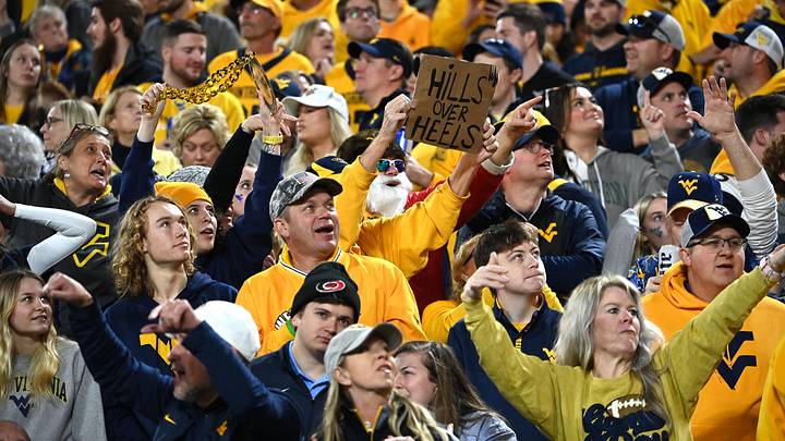 Dec 27, 2023; Charlotte, NC, USA; West Virginia Mountaineers fans cheer in the fourth quarter at Bank of America Stadium. Mandatory Credit: Bob Donnan-Imagn Images Dec 27, 2023; Charlotte, NC, USA; West Virginia Mountaineers fans cheer in the fourth quarter at Bank of America Stadium. Mandatory Credit: Bob Donnan-Imagn Images